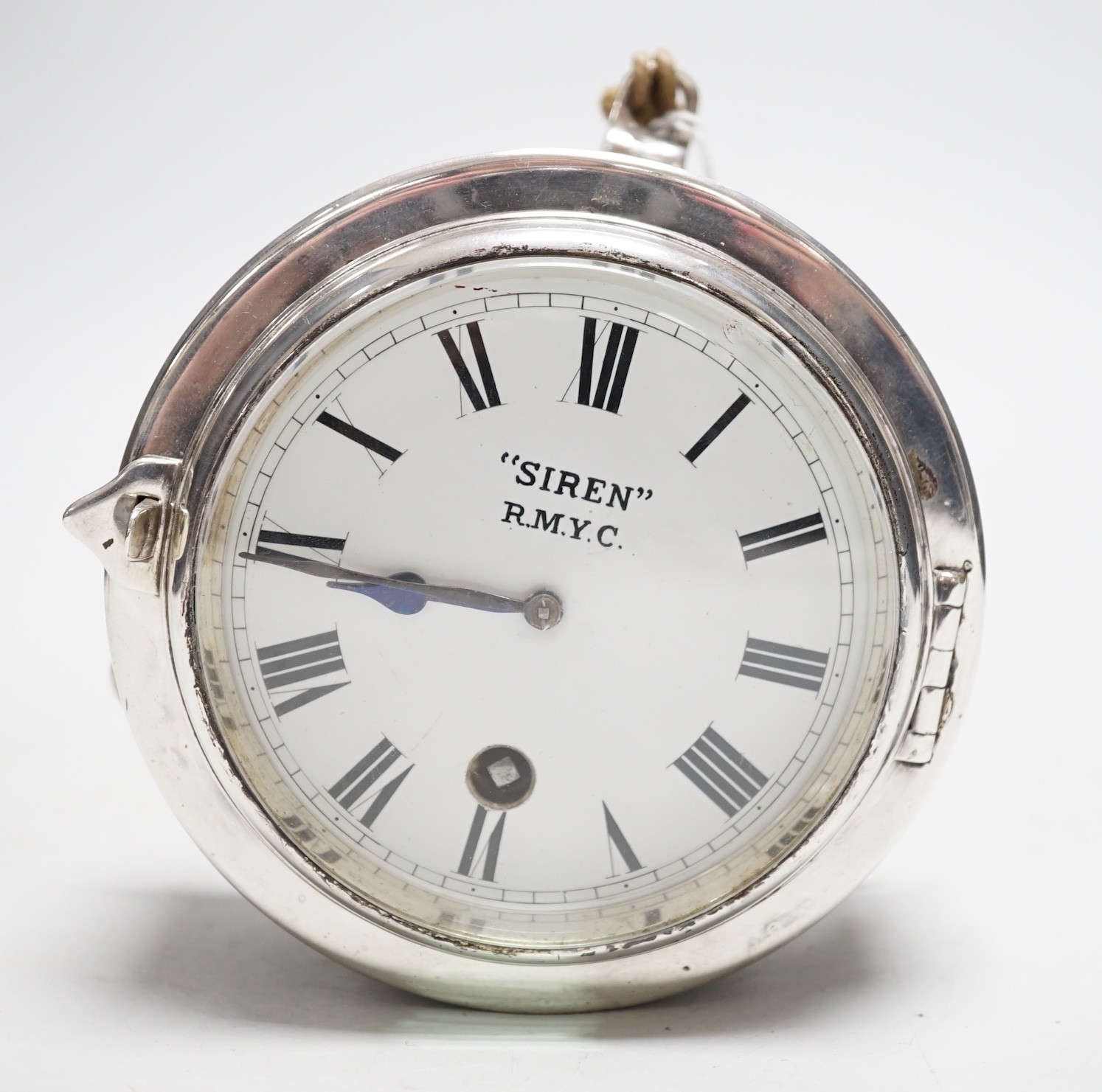 A small silver plated ship's clock, inscribed ‘Siren’ R.M.Y.C.